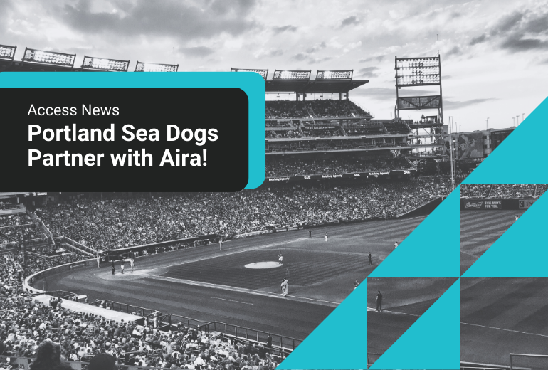 A black and white image of a baseball game at an outdoor field. In a black text box is white text which reads "Access News: Portland Sea Dogs Partner with Aira." In the bottom left corner are six teal right angle triangles which form a design element.