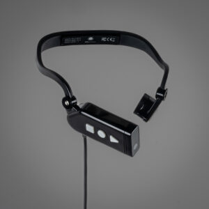 A grey background behind a ARx AI Gen1.5 wearable headset. The headset is black and the left end has a square shaped microphone. The right end has a rectangular shaped earpiece with white buttons: a square, a circle, and a triangle shape. Below the earpiece is a black cord hanging down out of frame. 