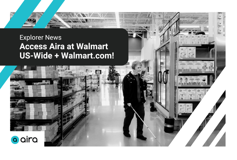 A woman walks through the grocery section of a Walmart store. In her right hand she holds a white cane, and in her left a cellphone up to her face. Text reads "Explorer News: Access Aira at Walmart US-Wide + Walmart.com!" Aira logo in bottom left, decorative lines in upper left and lower right.