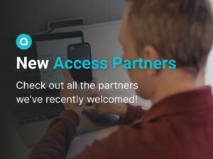 A man sits at a desk and holds his phone up to a laptop. Text: "New Access Partners: Check out all the partners we've recently welcomed!" Aira logo at top.